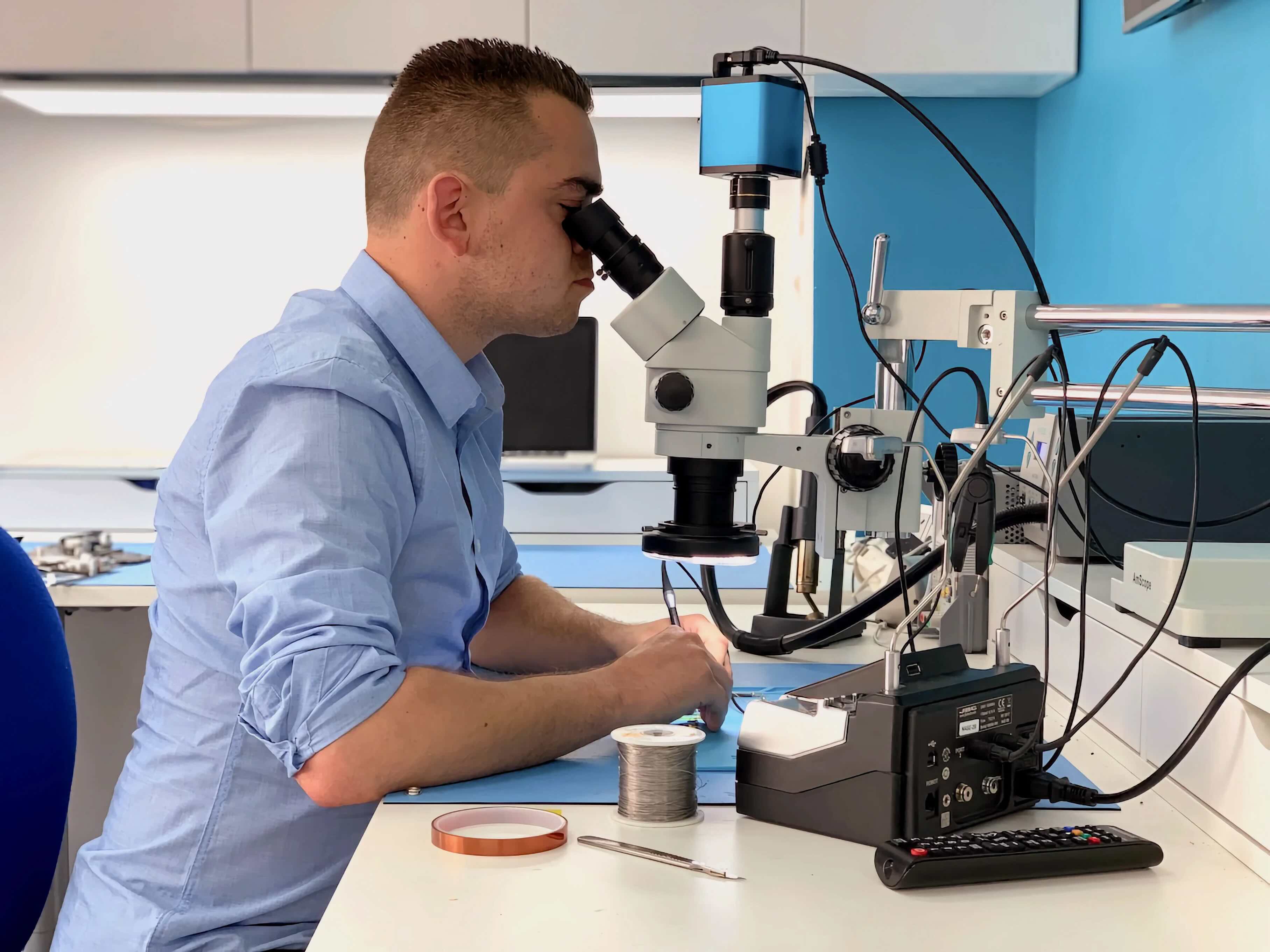 Technician using a microscope for a microsoldering job