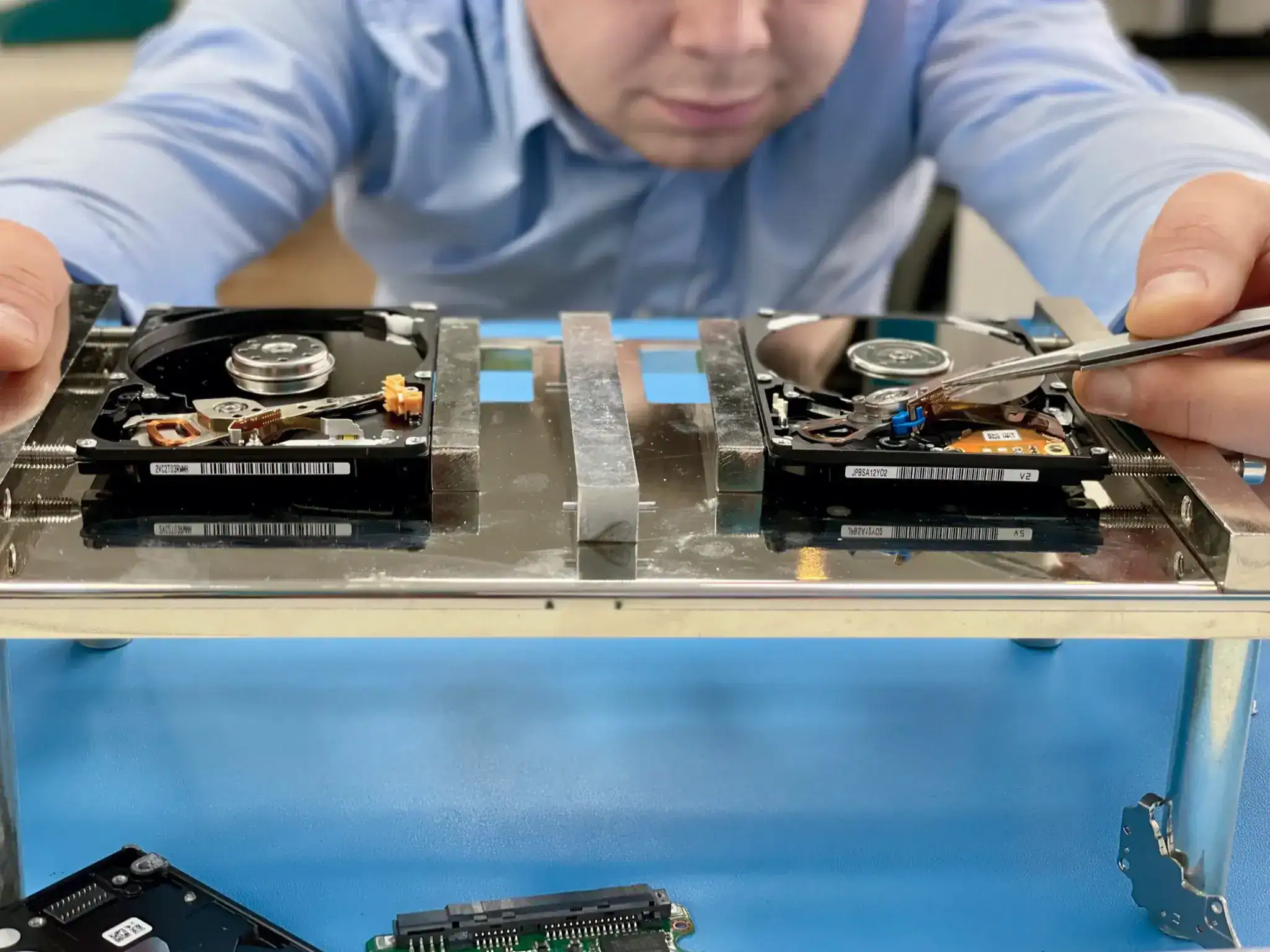 Fixfactor data recovery specialist performing hard drive head swap using professional PC3000 equipment for advanced data recovery services